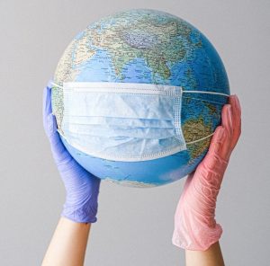 hands with latex gloves holding a globe with a face mask 4167544